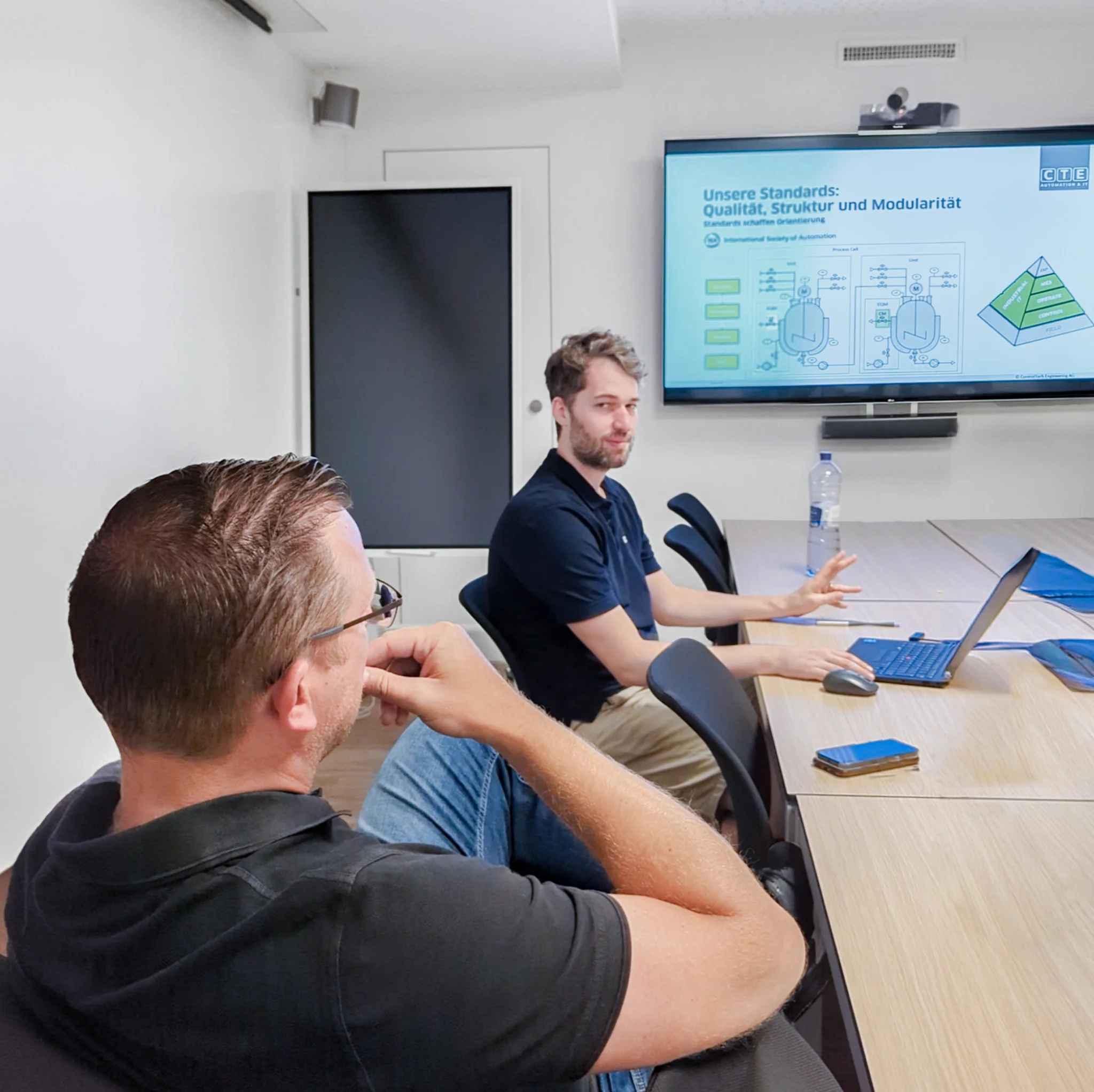 Patrick Habl&uuml;tzel (Automation Engineer) und Dominic Brunner (CEO) bei einer Pr&auml;sentation im Sitzungszimmer der Firma CTE.